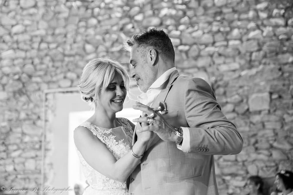 Les mariés dansent en noir et blanc, seuls dans leur bulle, se regardant tendrement